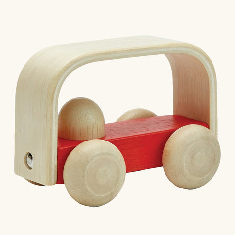 Wooden toy with a red base and beige wheels on a white background